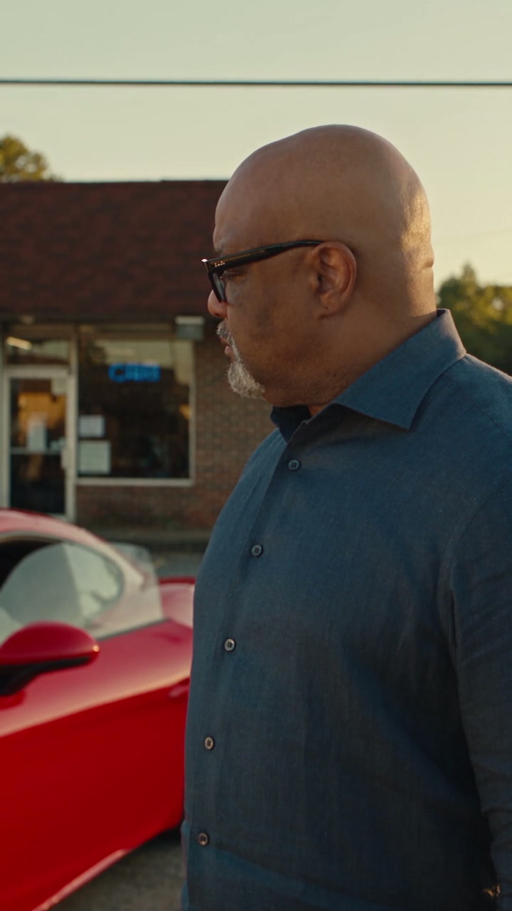 Dr. Boyce beside a red sports car in a Cozy Digital client film